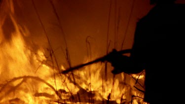 Fireman with hose tries to put fire out