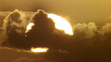 Sun setting behind clouds