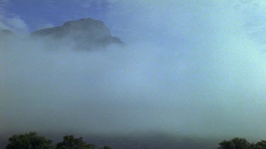 Mountain peaks stick out above low lying cloud.