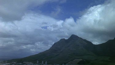 Dark rain clouds gathering over Table Mountain. City of Cape Town at foot of mountain.