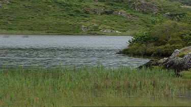 Irish Scenery. Lake pan to the Twelve Bens Mountain range  Connemara County Galway. Cloud over mountain summit. Mist rolling down hills.