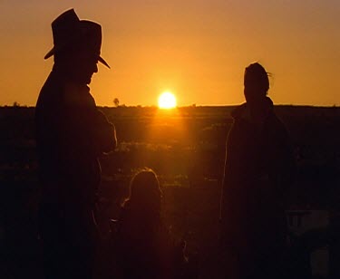 Cowboys with campfire at sunset. Silhouette. Billycan