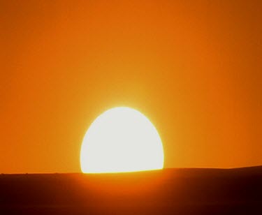 Sun on horizon. Sunrise big yellow ball and orange sky.