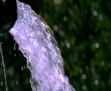 water flowing pouring falling into a pond splashing droplets