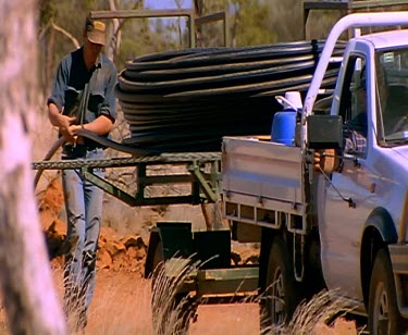 Farming ploughing tractor laying out pipe