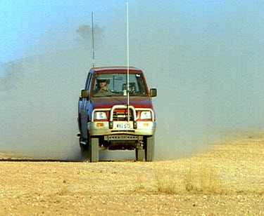 Tracking 4x4 across desert. Flock of emu run across desert.