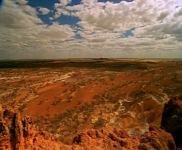 clouds and outback desert red rocky land and shadows