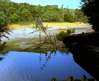 Ruined huon pine wooden structure on banks of river. Probably used during logging of huon pine forest.