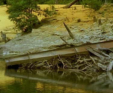 Ruined huon pine wooden structure on banks of river. Probably used during logging of huon pine forest.