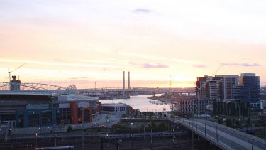 A stunning sunset lights up the sky and welcomes the incredible lights displayed on the outskirts of the city. Day to night.