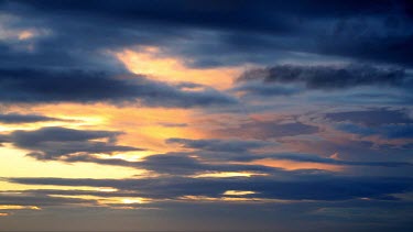 A pictuesque clip of fast moving clouds is accentuated by the contrasting colours of a sunset background.