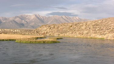 A pristine river runs through a  desert valley