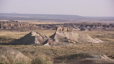 Grassy desert valley with mounds, buttes and mesas