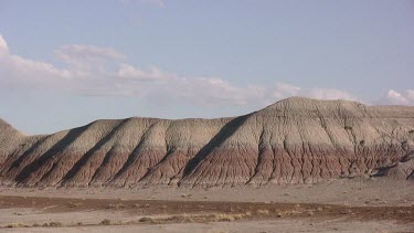 Desert valley with distant mounds and hills; moonscape