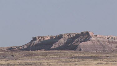 Grassy desert prairie plains valley with mesas in the distance