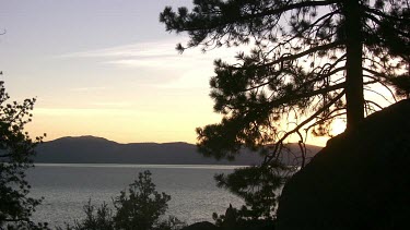 Rippling lake in alpine setting with distant shoreline at sunrise or sunset