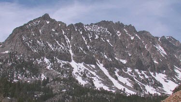 Snowy mountains, blue sky, clouds and forest