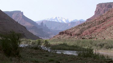 River flows through southwestern canyon with distant snowy peak