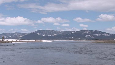 A broad Rocky Mountain river in early Spring; the Snake River