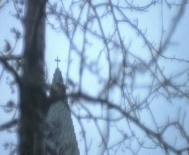 Cross On A Church Steeple Through Some Branches