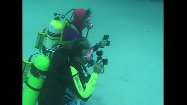 A Great White Shark swims slowly past divers testing the Shark POD device