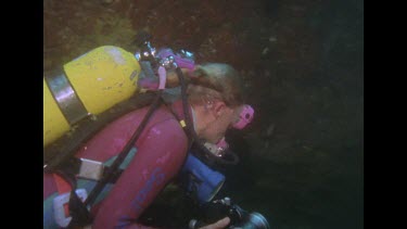 Valerie swims into the distance, camera drops to tropical fish on floor