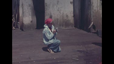 pan from Valerie photographing workers to workers cutting up whale meat