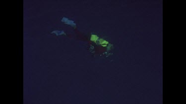 Diver just below the surface topside, bubbles reach surface
