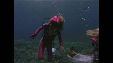 Valerie Taylor and Justine hand feeding and interacting with fish.