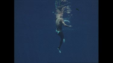 looking up at bikini clad woman swimming and treading water