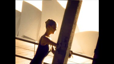 Sepia tones. Ballet dancers warming up at the barre, Sydney Opera House in background