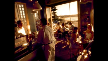 Sepia. A cafe with people drinking coffee. Bondi Beach in background