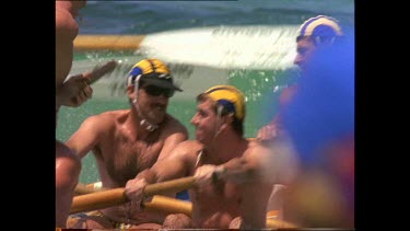 Lifesavers rowing out to sea, through the breaking waves