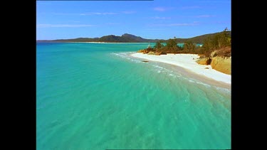 Catamaran crosses clear, calm tropical Whitsunday's sea.