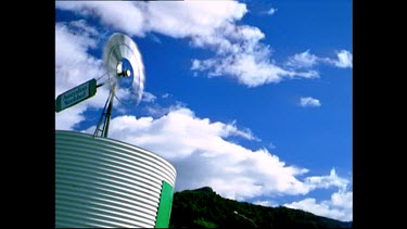 Windmill on top of water tank, clouds pass overhead. Port Douglas.