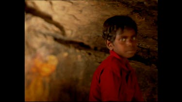 Face of Aboriginal child, rock art background.