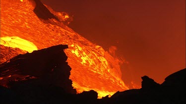 Volcano night. The lava flow picks up bits of solid lava crust and carries it into the ocean.