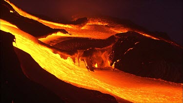 Volcano night. Lava flowing quickly.