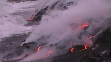 Lava flowing directly into ocean. Waves turning to steam.