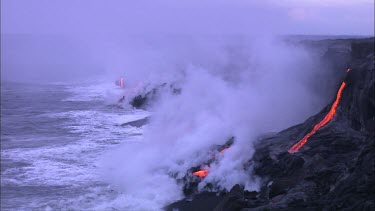 Lava flowing directly into ocean. Waves turning to steam.