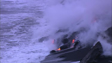 Lava flowing directly into ocean. Waves turning to steam.