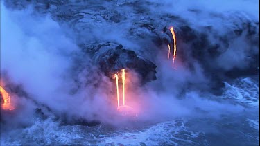 Where the edge of the Kilauea lava delta meets the ocean a line of steam rises into the air. Lava being washed out to sea.