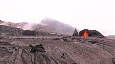 Lava bubbling through vents and flowing down channel. The lava is flowing beneath the solidified crust in lava tubes,