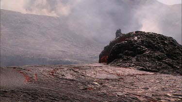 Lava bubbling and erupting from vent and flowing down lava channel