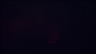 Lava sputtering and erupting out of a vent. Volcanic eruption. Night