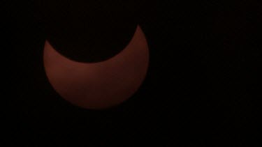 close up partial solar eclipse with clouds moving in foreground -israel 2011