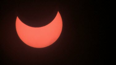 close up partial solar eclipse with clouds moving in foreground -israel 2011