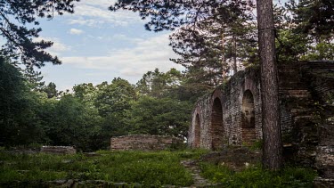 Vibrant time-lapse of ruins within nature; Trees, clouds and a taste of sunlight