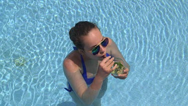 Teenage Girl In Swimming Pool Drinking Cocktail, Elounda, Crete, Greece