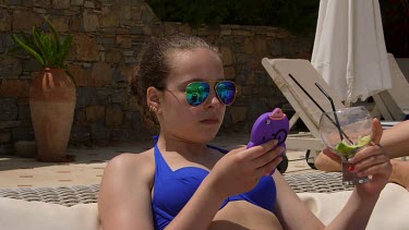 Teenage Girl On Mobile Phone Drinking Cocktail, Elounda, Crete, Greece